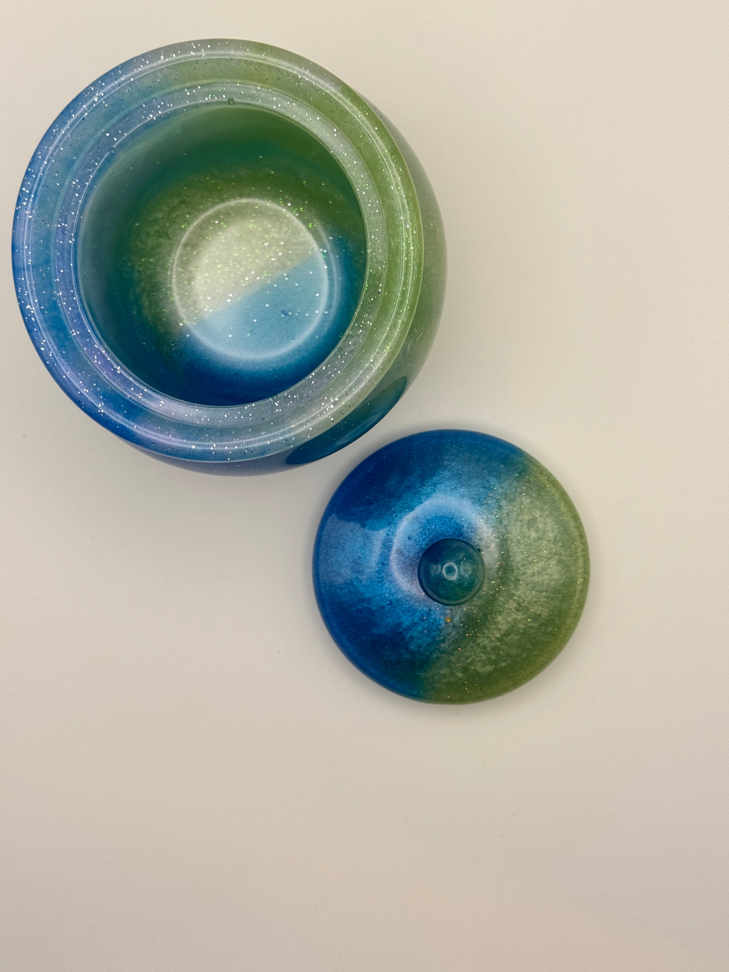 Mermaid Lagoon lidded resin jar closed, showing ocean blue and sage green swirl with glitter finish