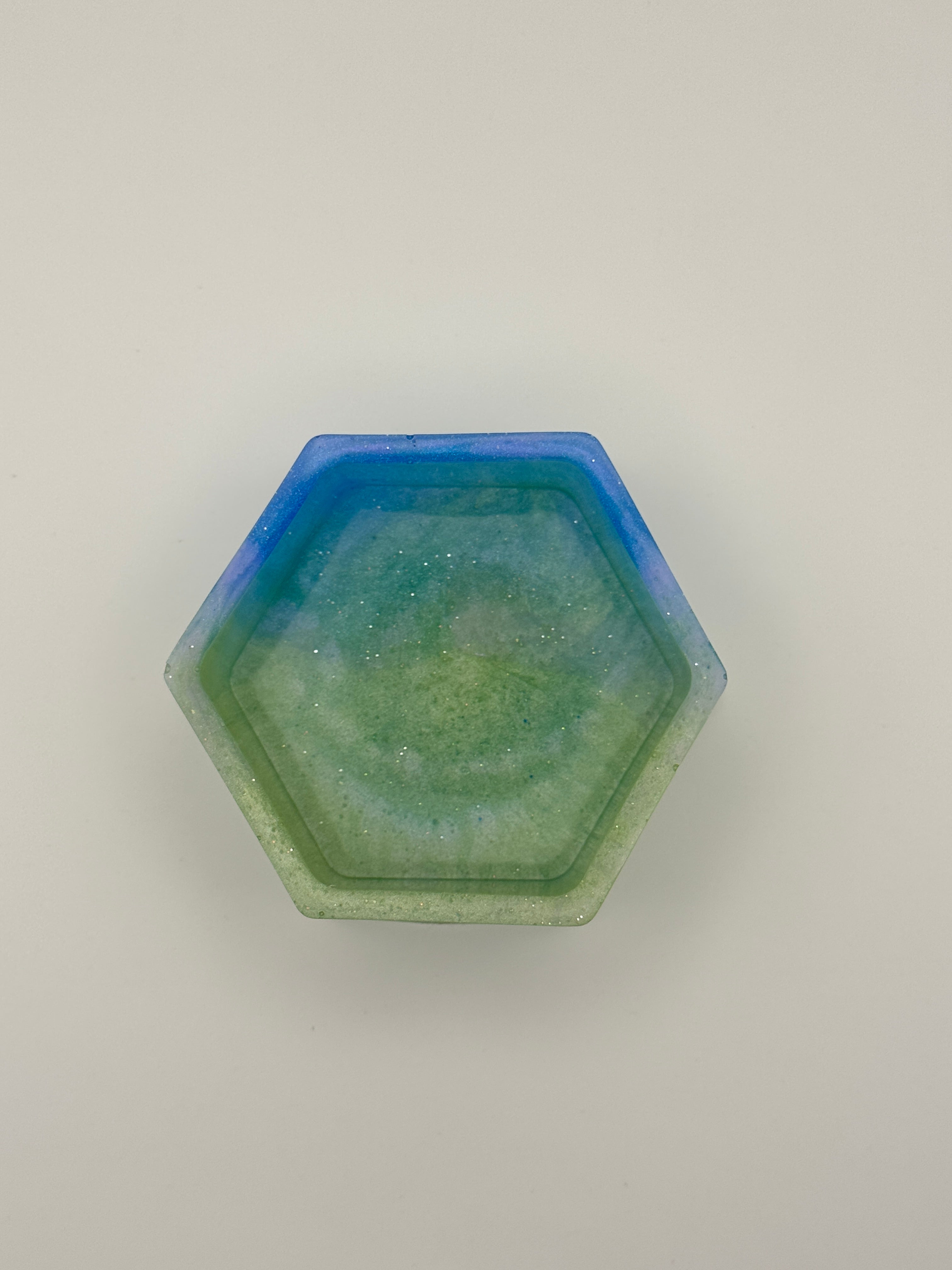 Mermaid Lagoon hexagon resin dish from above, showing ocean blue rim and sage green glitter interior